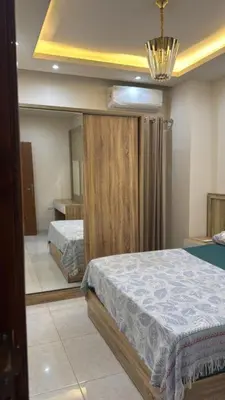 a bedroom with two beds and a large window at Moon Apartment Hurghada in Hurghada