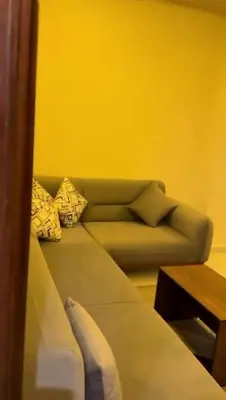 a couch in a living room with a yellow wall at Moon Apartment Hurghada in Hurghada