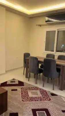 a room with a table and chairs and a rug at Moon Apartment Hurghada in Hurghada