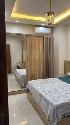 a bedroom with two beds and a mirror at Moon Apartment Hurghada in Hurghada