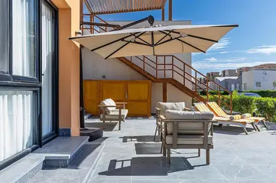 a patio with chairs and an umbrella on a building at Wonderful Holiday Home in Stunning Soma Bay in Hurghada