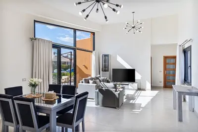 a living room with a table and chairs and a tv at Wonderful Holiday Home in Stunning Soma Bay in Hurghada