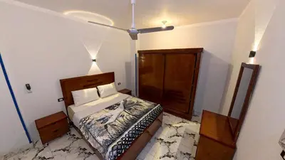 a bedroom with a bed and a ceiling fan at Alia House in Luxor