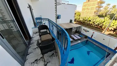 a balcony with a chair and a swimming pool at Alia House in Luxor