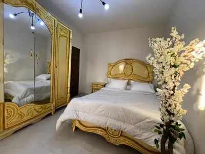 a bedroom with a gold bed and a mirror at Modern Riverside Apartment 3BR in Aswan Downtown in Aswan