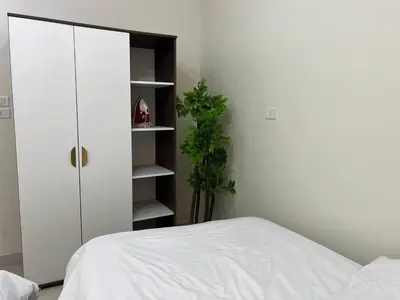 a bedroom with a bed and a cabinet and a plant at Modern Riverside Apartment 3BR in Aswan Downtown in Aswan