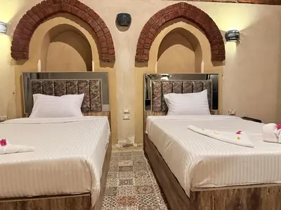 two beds in a room with arches at Saray ElOmda Wellness - Retreat Village in Al Karnak