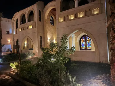 a large building with a stained glass window at night at Saray ElOmda Wellness - Retreat Village in Al Karnak