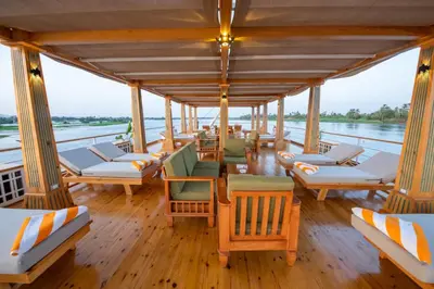 a boat with chairs and tables on the water at Azhar II Dahabiya Luxury Nile Cruise in Luxor
