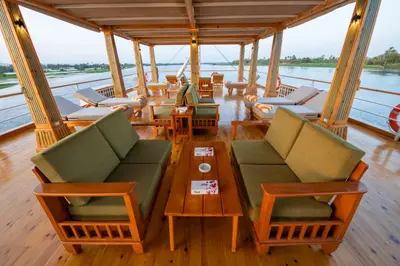 a boat with chairs and tables on the water at Azhar II Dahabiya Luxury Nile Cruise in Luxor