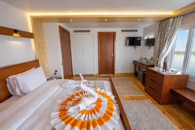 a bedroom with a large bed with a bowl on it at Azhar II Dahabiya Luxury Nile Cruise in Luxor