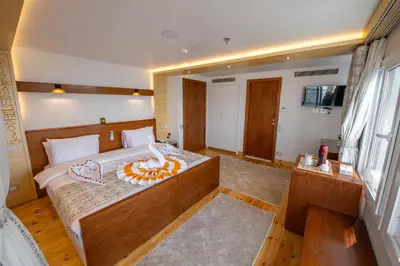 a bedroom with a large bed and a large window at Azhar II Dahabiya Luxury Nile Cruise in Luxor