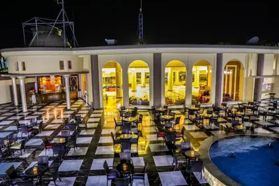a hotel patio with chairs and a pool at night at One Bedroom Chalet Mirage Bay in Hurghada