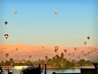 a bunch of hot air balloons flying in the sky at Jewel Luxor Hotel Nile View in Luxor