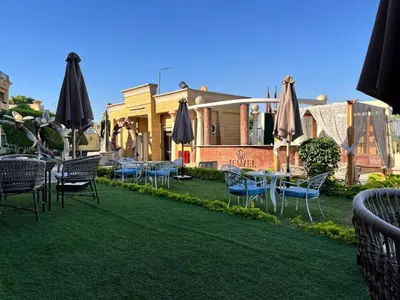 a group of chairs and umbrellas on a lawn at Jewel Luxor Hotel Nile View in Luxor