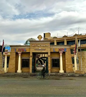 a person riding a bike in front of a building at Jewel Luxor Hotel Nile View in Luxor