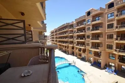 a balcony of a building with a swimming pool at Turtles Beach Resort in Hurghada in Hurghada