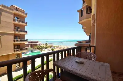 a balcony with a table and a view of the beach at Turtles Beach Resort in Hurghada in Hurghada