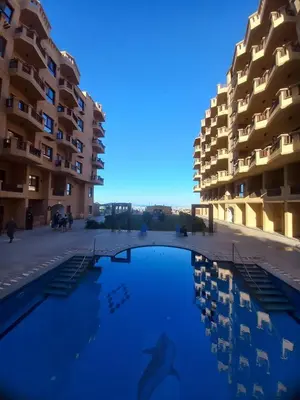 a swimming pool in front of some apartment buildings at Turtles Beach Resort in Hurghada in Hurghada