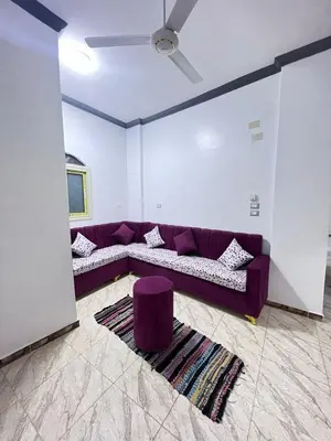 a living room with a purple couch and a rug at Anas Nubian Guest House in Aswan