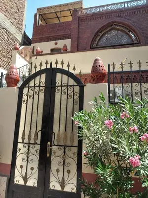 a black gate in front of a building with flowers at The Nile Dome Garden Suite in Luxor