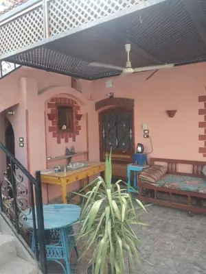 a patio with a table and a bench in a house at The Nile Dome Garden Suite in Luxor