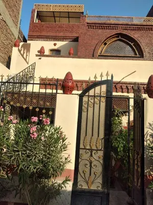 an entrance to a house with a gate and flowers at The Nile Dome Garden Suite in Luxor