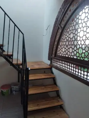 a wooden staircase with a wrought iron railing at Nileview Terrace Dome Apartment in Luxor