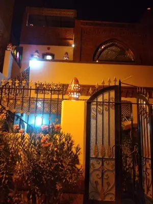 a building with an iron gate and a restaurant at Nileview Terrace Dome Apartment in Luxor