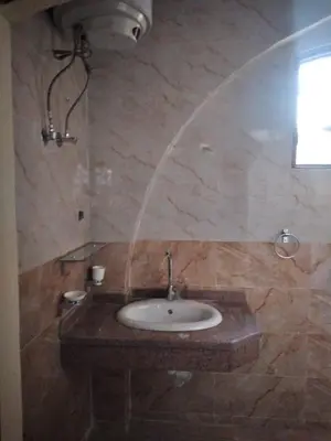a stone bathroom with a sink and a window at Nileview Terrace Dome Apartment in Luxor