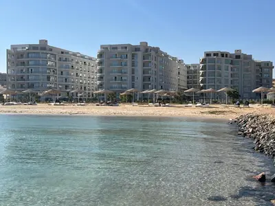 a beach with some umbrellas and some buildings at Scandic Resort Sea View Room in Hurghada