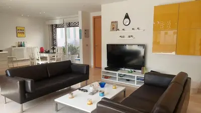 a living room with a black couch and a tv at Sunny 2 bedroom retreat - Scarab Club - El Gouna in Hurghada