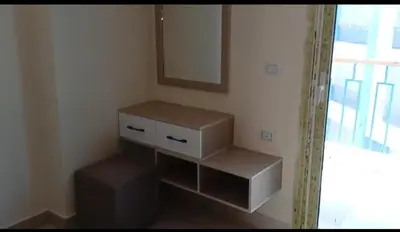 a bathroom with a dresser and a mirror and a stool at Mirage aquapark resort 776c in Hurghada