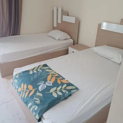 a small bedroom with two beds and a blanket at Mirage aquapark resort 776c in Hurghada