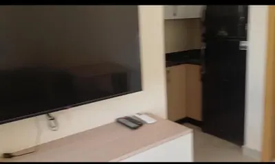 a television on a wall with two remote controls at Mirage aquapark resort 776c in Hurghada