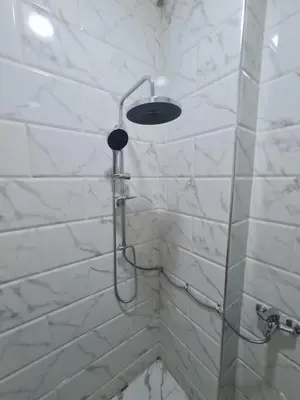 a shower with a shower head in a bathroom at Modern Pool View 1BR with Balcony Prime Location on Hurghada Vibrant Promenade in Hurghada