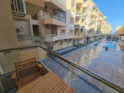 a balcony with a bench and a swimming pool at Modern Pool View 1BR with Balcony Prime Location on Hurghada Vibrant Promenade in Hurghada