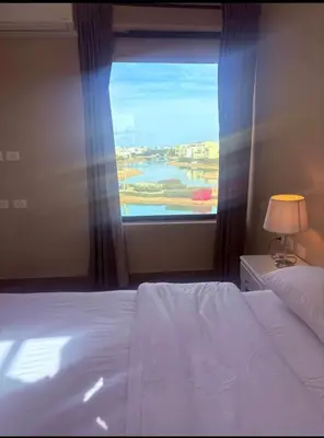 a bedroom with a bed and a large window at Chic condo at Tawila 1BR El Gouna in Hurghada