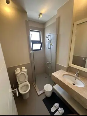 a bathroom with a shower and a toilet and a sink at Chic condo at Tawila 1BR El Gouna in Hurghada