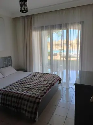 a bedroom with a bed and a large window at كمباوند ذا فيو The View Compound in Hurghada