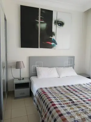 a bedroom with a bed and a picture of a woman at كمباوند ذا فيو The View Compound in Hurghada
