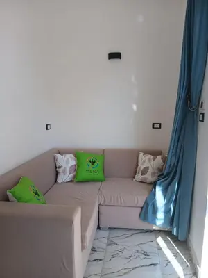 a couch in a living room with blue curtains at Villa Mena Luxor in Luxor