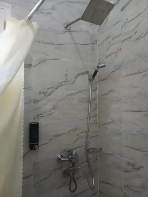 a shower in a bathroom with a stone wall at Villa Mena Luxor in Luxor