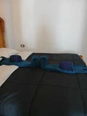 a bed with a blue blanket and pillows on it at Villa Mena Luxor in Luxor