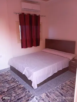 a bedroom with a large bed with red curtains at oasis resort ,areada HRG in El Gouna