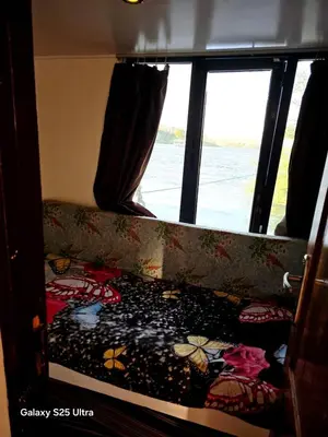 a bed in the back of a bus with a window at The Grand in Aswan