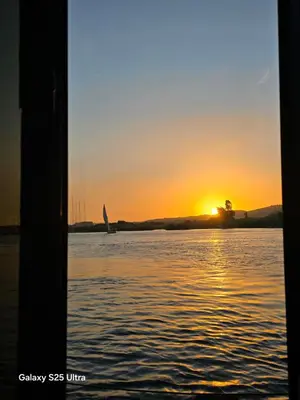 a sunset seen from a boat in the water at The Grand in Aswan