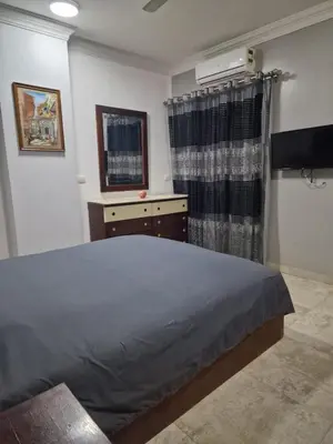 a bedroom with a bed and a dresser and a window at Kawthar Apartment in Hurghada