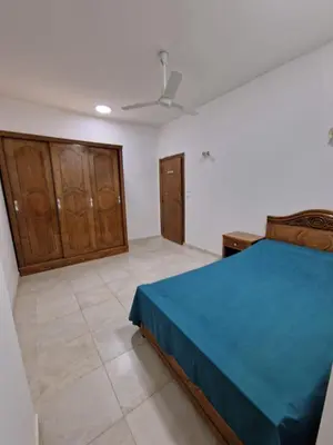 a bedroom with a blue bed and wooden cabinets at Kawthar Apartment in Hurghada