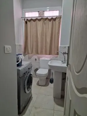 a bathroom with a toilet sink and a washing machine at Kawthar Apartment in Hurghada